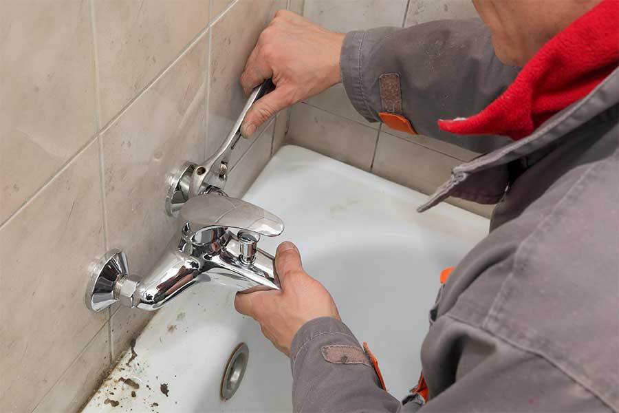 Plumber installing a bathtub faucet in Brooklyn, NY